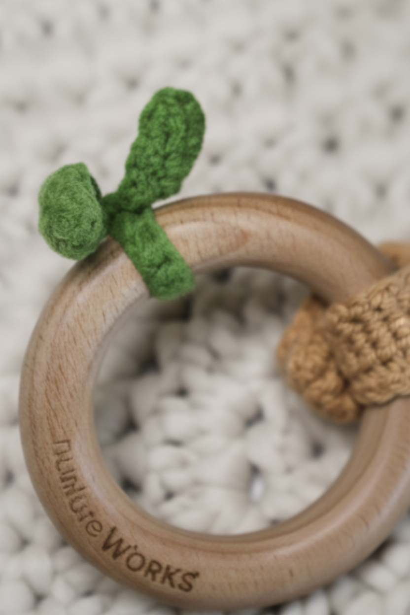 Wooden ring with a green crochet leaves object on a textured surface