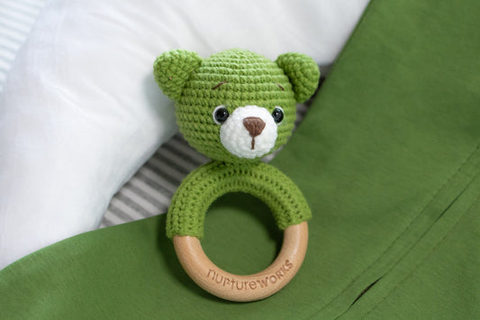 Green crochet rattle with wooden handle. 