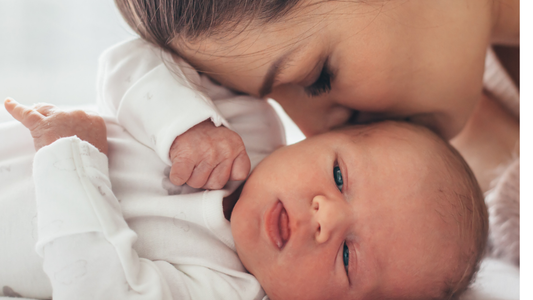 Mother kissing her newborn 