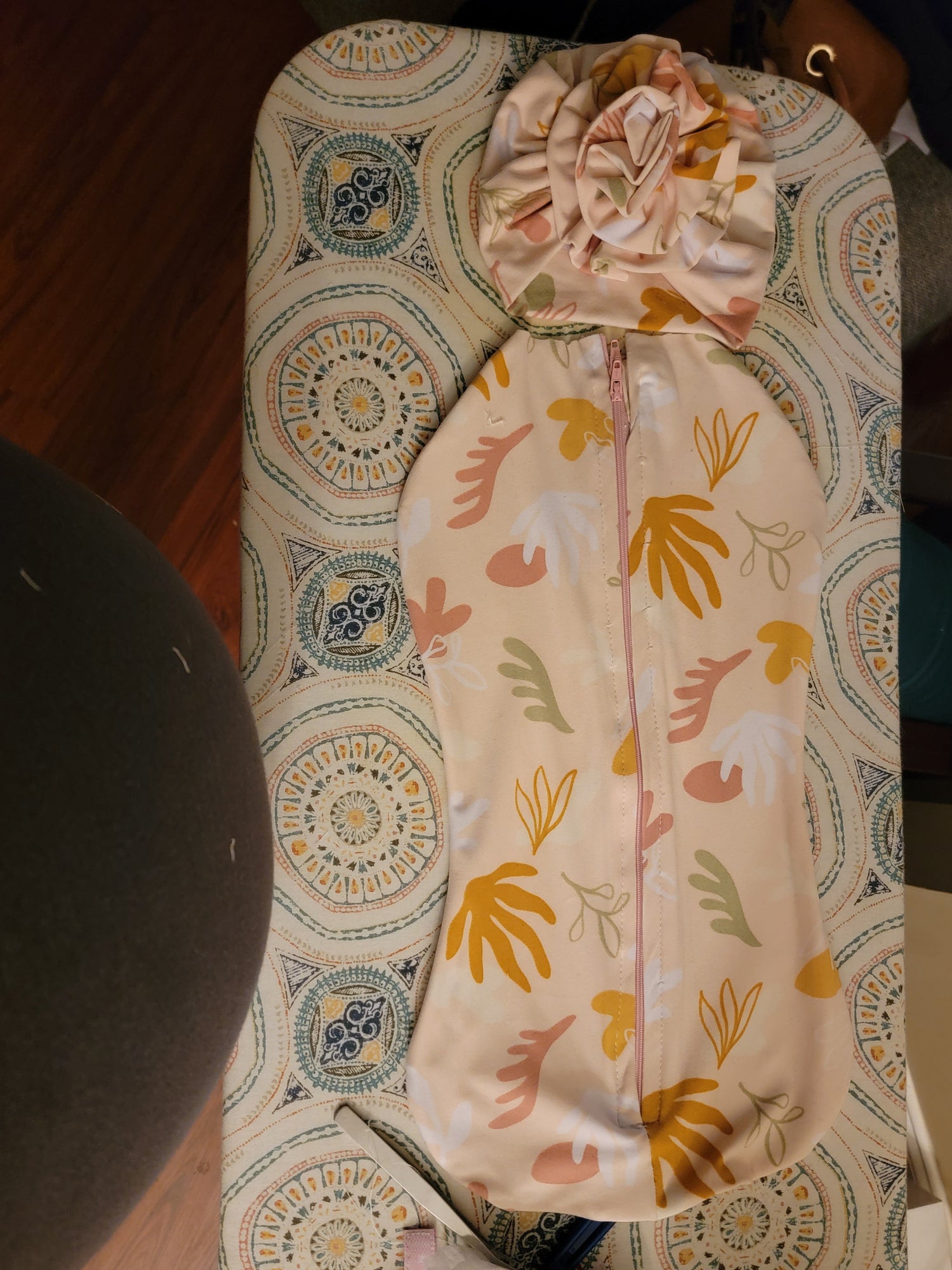 Floral-patterned sleep sack with matching turbin on a patterned surface