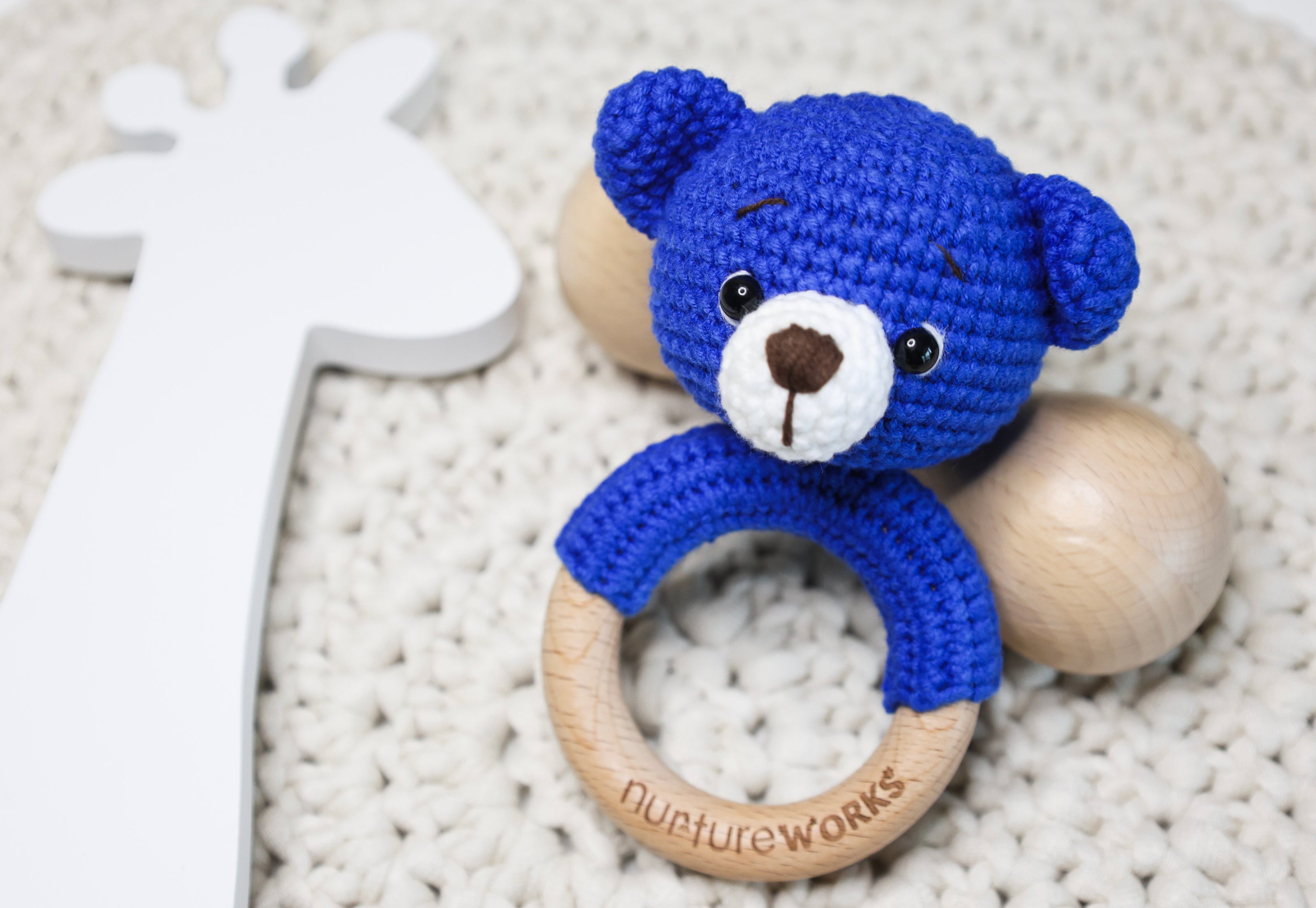 Blue crochet bear rattle with a wooden ring.